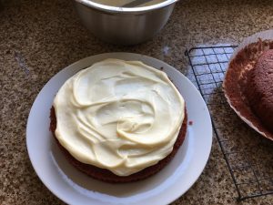 Decorating gluten free red velvet cake with a cream cheese frosting
