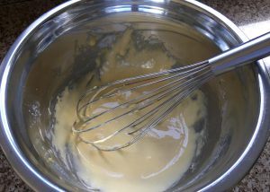 Ingredients for homemade custard whisked together in a bowl.