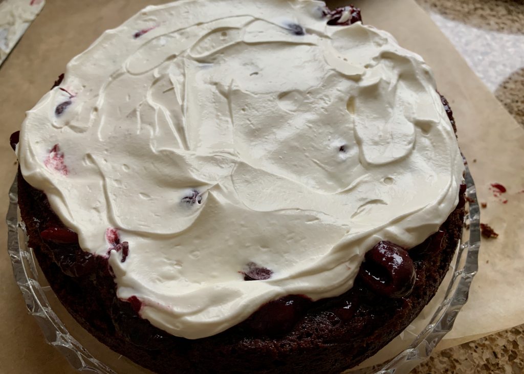 Gluten free chocolate sponge topped with cream and cherry compote