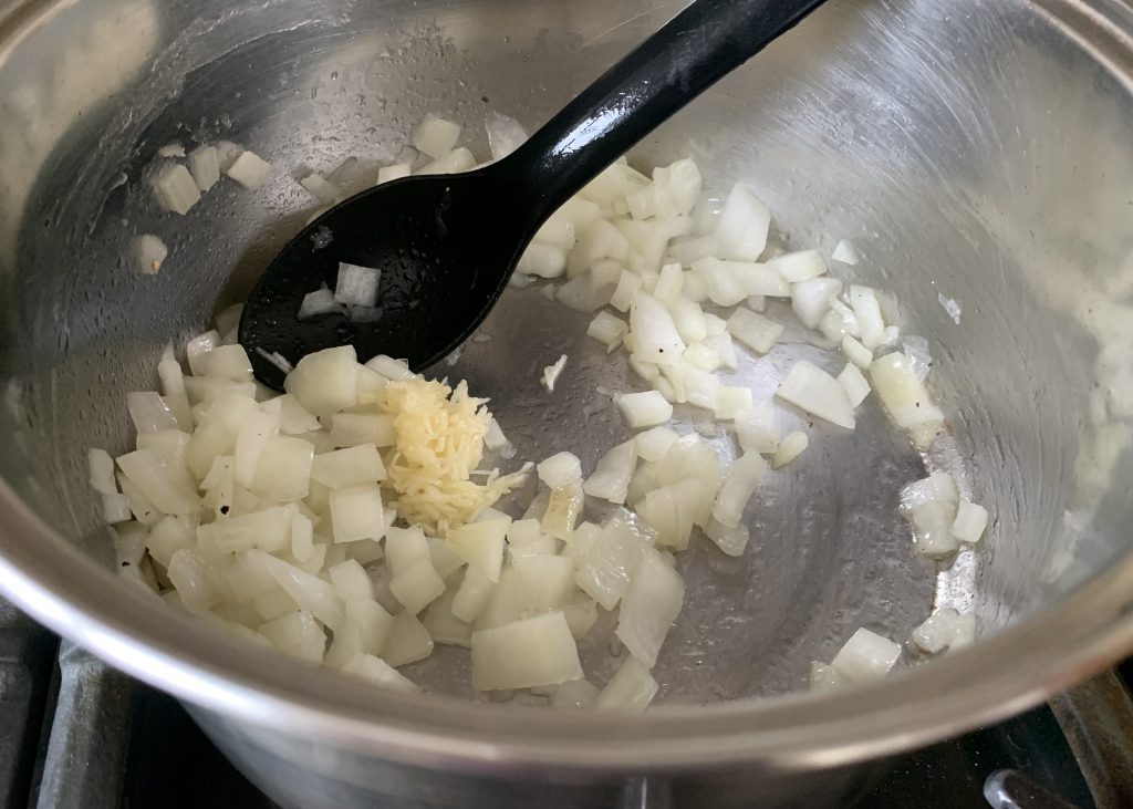 Chopped onions in a pan with grated garlic
