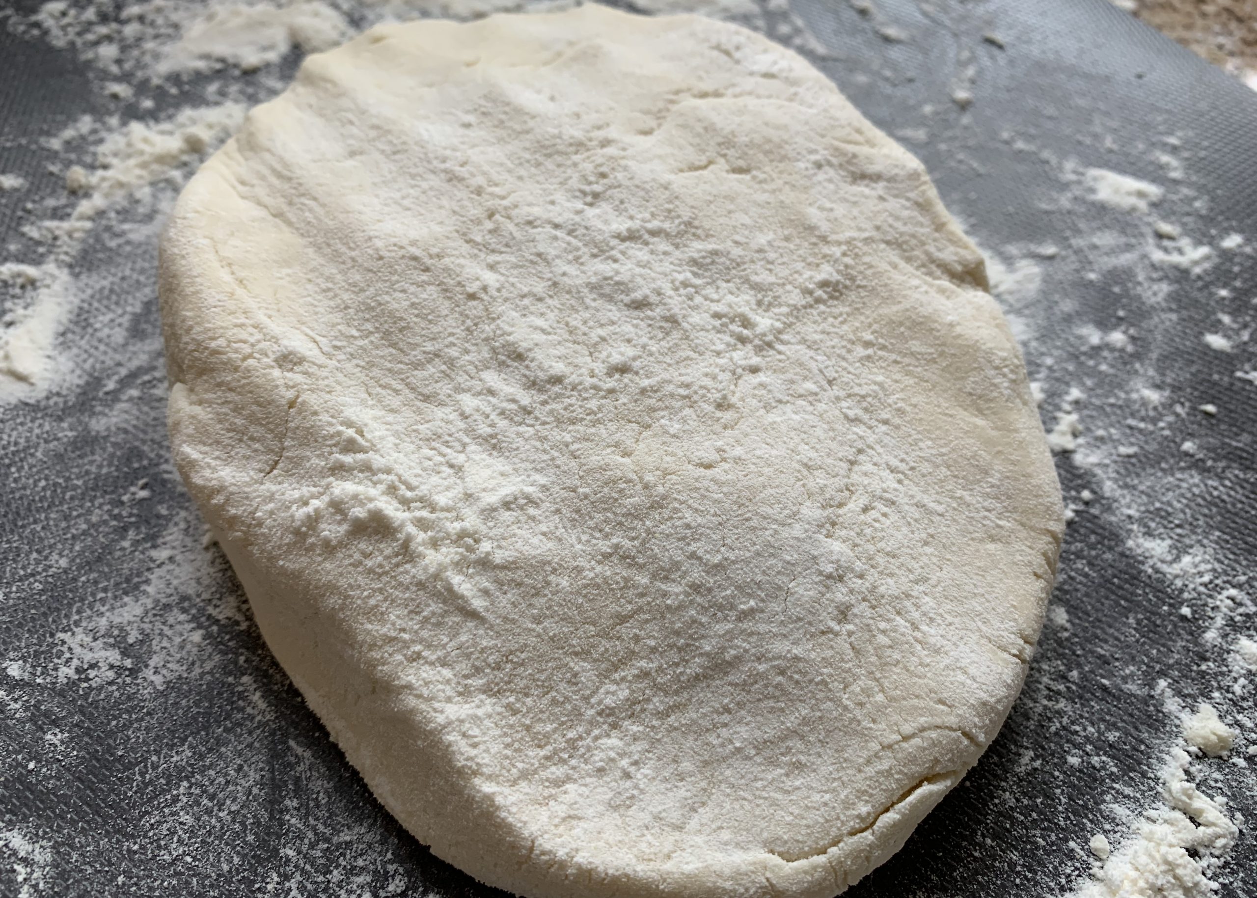 Gluten free pizza base dough on a surface dusted with gluten free flour 