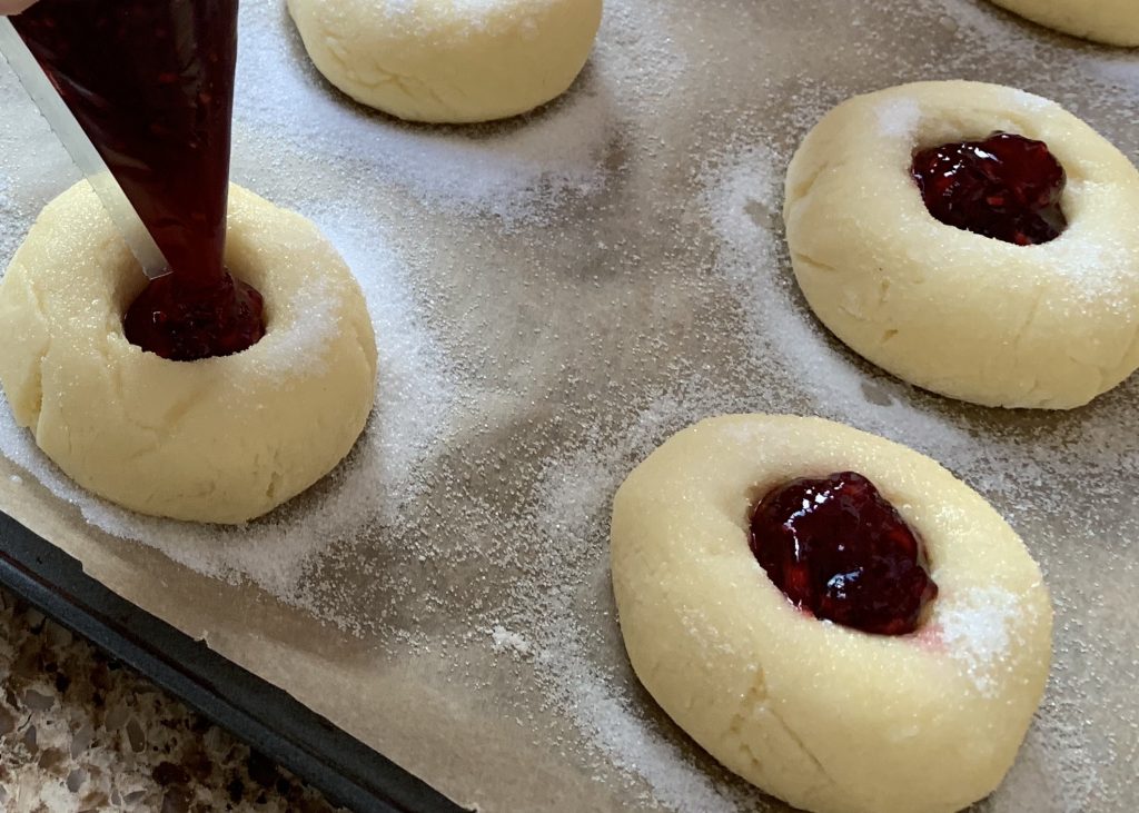 Filling gluten free raspberry buns with jam