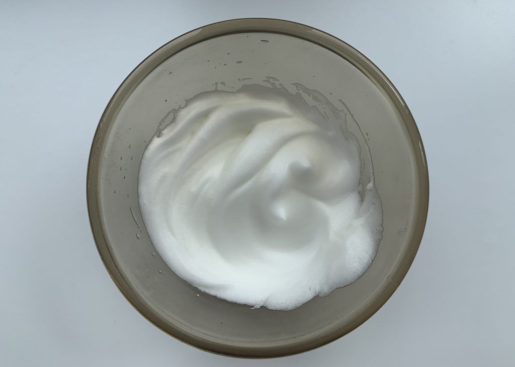 Whipped egg whites in a glass bowl