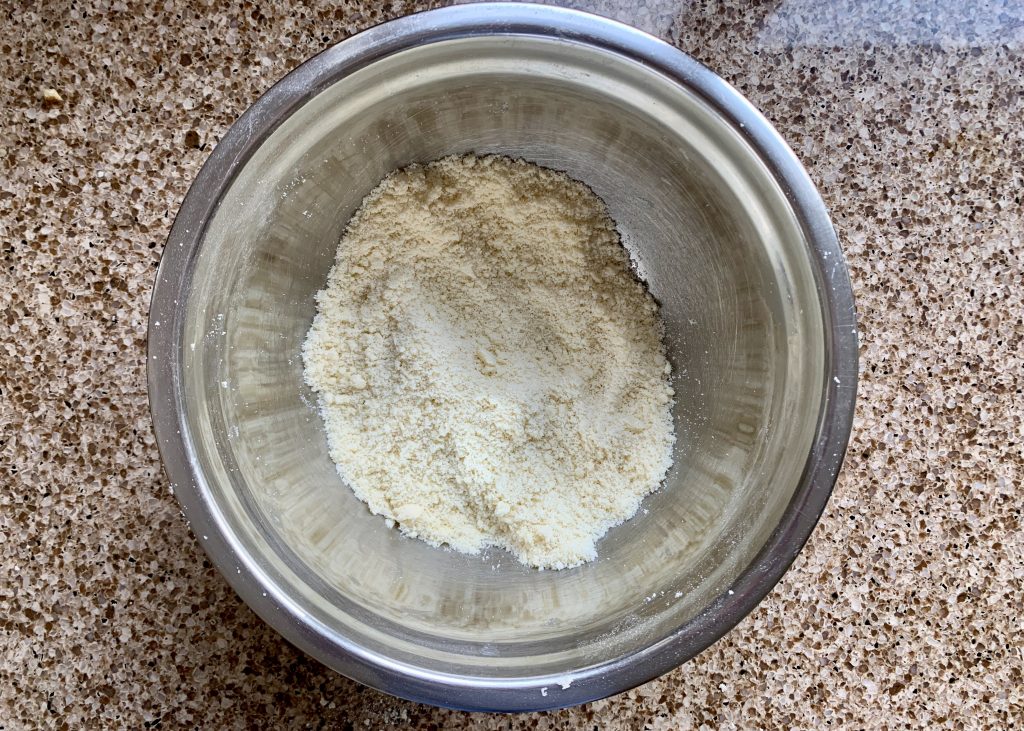 Gluten free flour and butter rubbed together in a stainless steel bowl