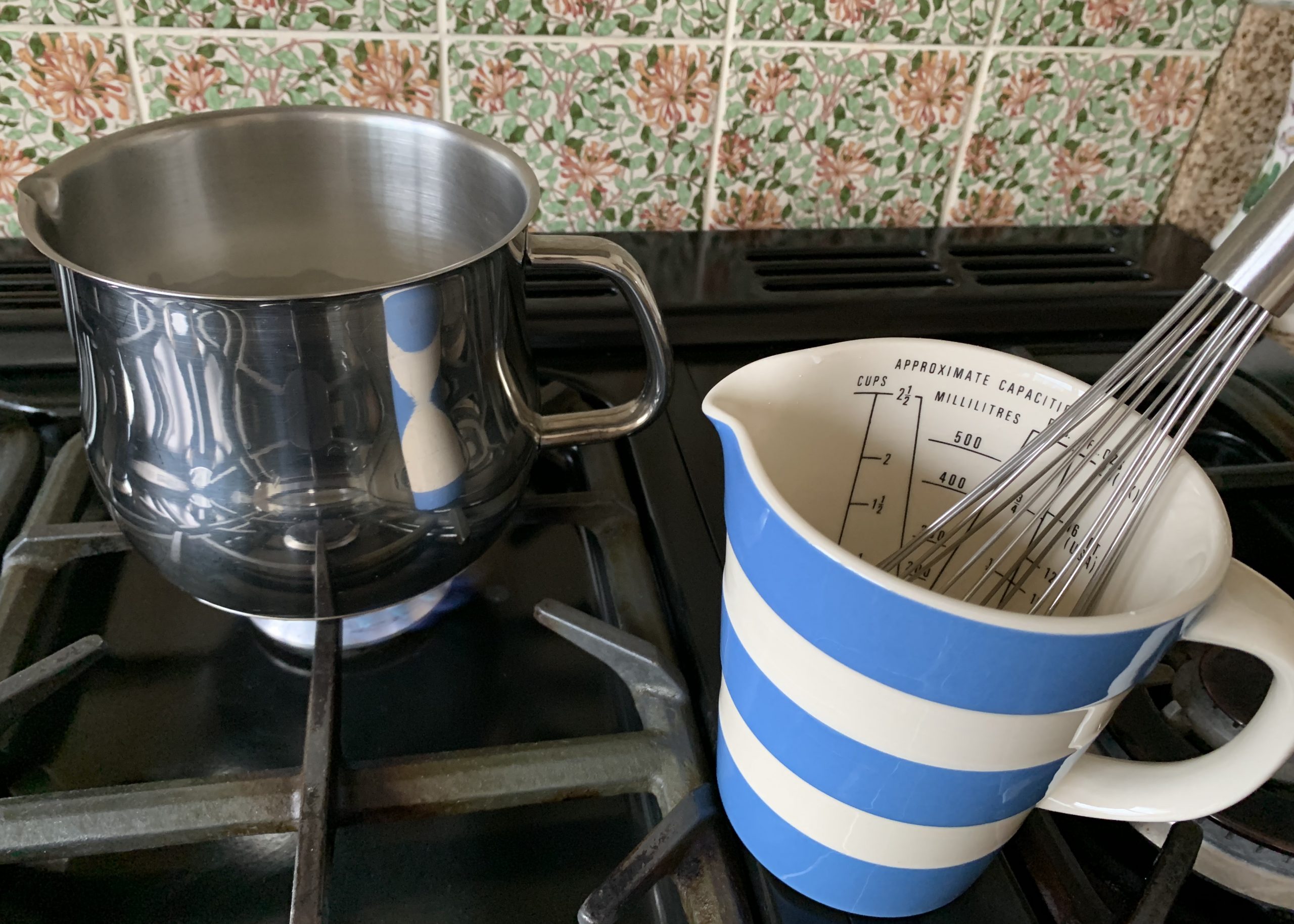 Milk in a pan and a blue and white striped jug