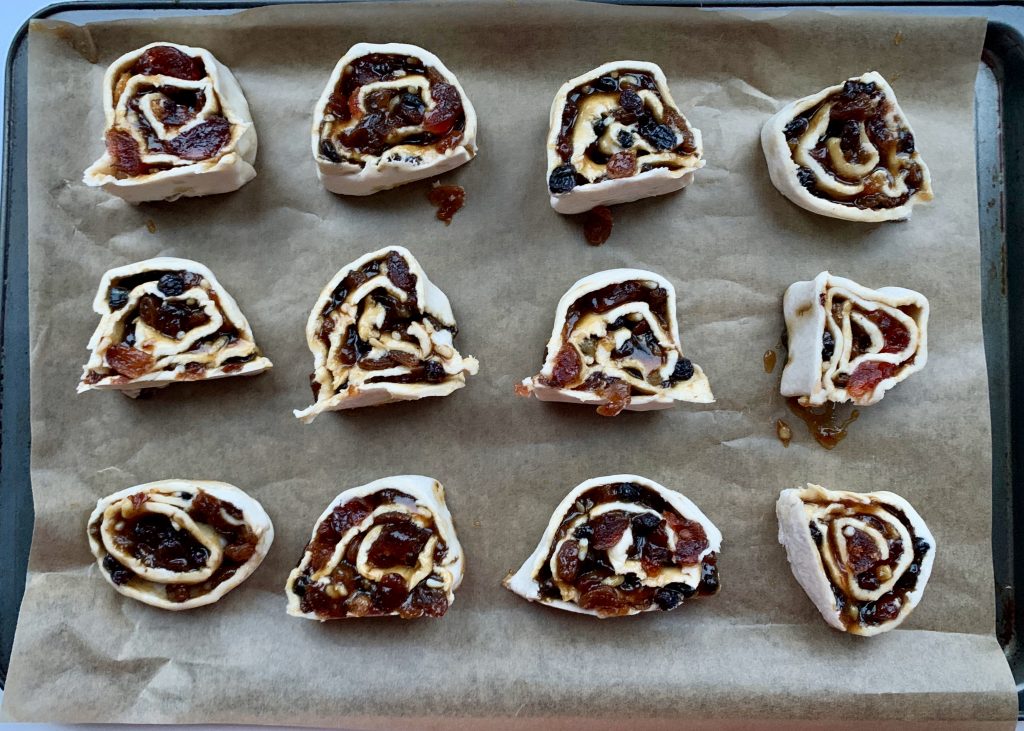 Gluten free mincemeat, cherry and almond swirls on a baking tray before being baked