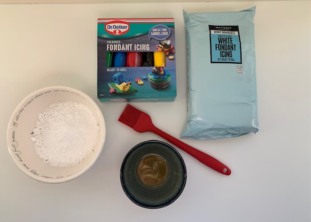 Flatlay on ingredients needed to cover a Christmas cake with fondant icing