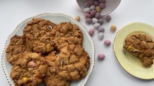 Gluten free Easter cookies on a plate and Cadburys mini eggs