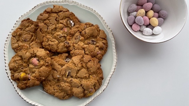 Gluten free Easter cookies on a plate and Cadburys mini eggs in a bowl