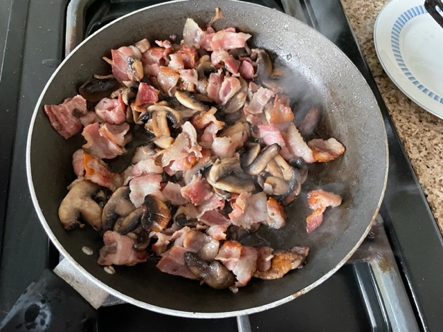 Bacon and mushrooms in a frying pan