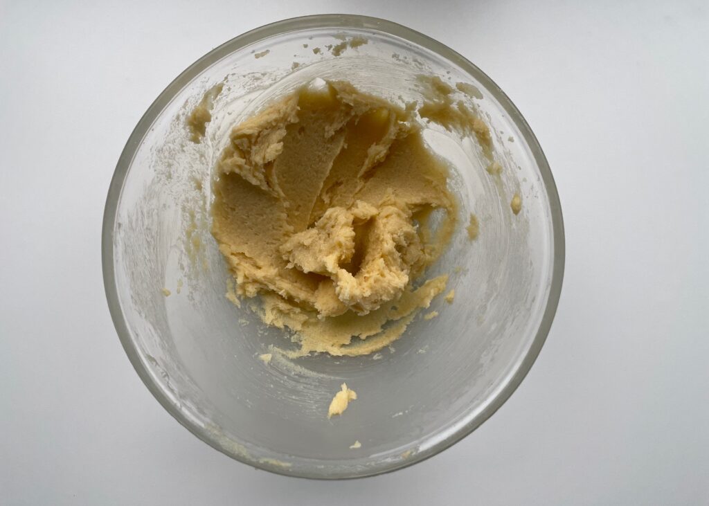Golden caster sugar and butter creamed together in a glass bowl