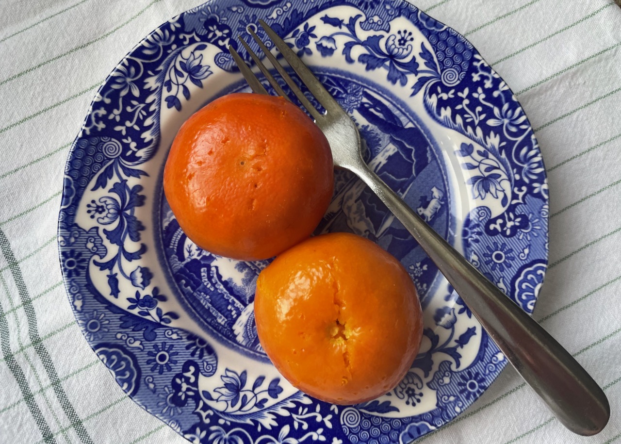 Two satsumas on a blue china plate 