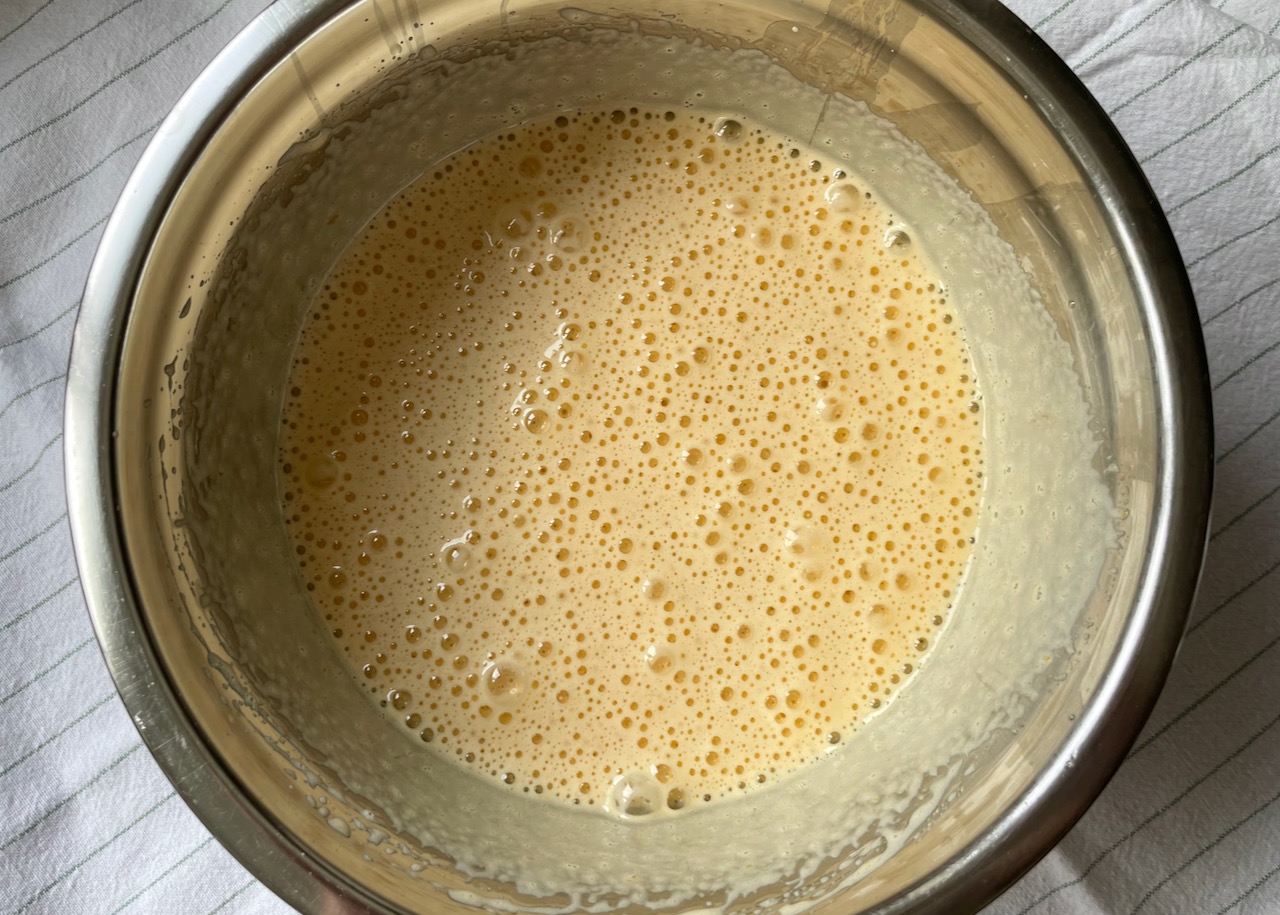 Eggs and golden caster sugar whipped up in a bowl