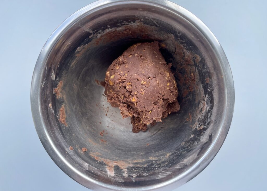 Gluten free chocolate biscuit dough in a large stainless steel bowl