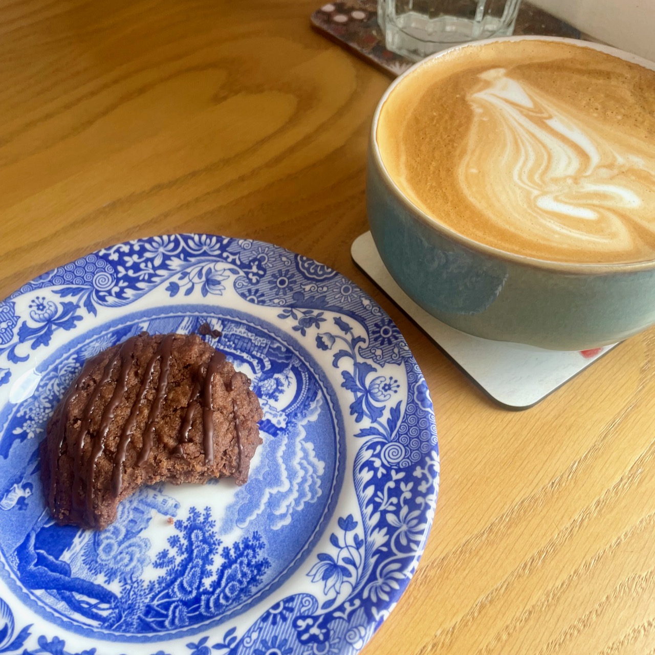 Gluten free chocolate biscuit on a blue china plate and a cup of coffee 